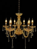 An ornate gold chandelier with six candle-style bulbs, clear crystal teardrop pendants, and a hanging chain